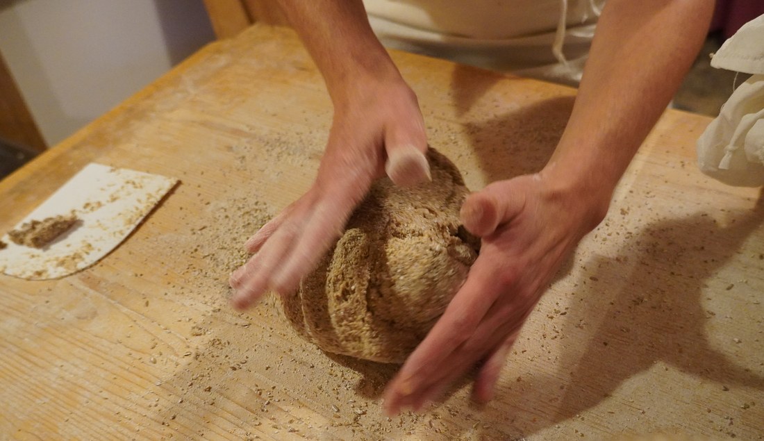 Mãos sovando massa de pão artesanalmente, tradição de padaria familiar