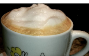 Cappuccino servido na xícara com a logo da Flor das Américas